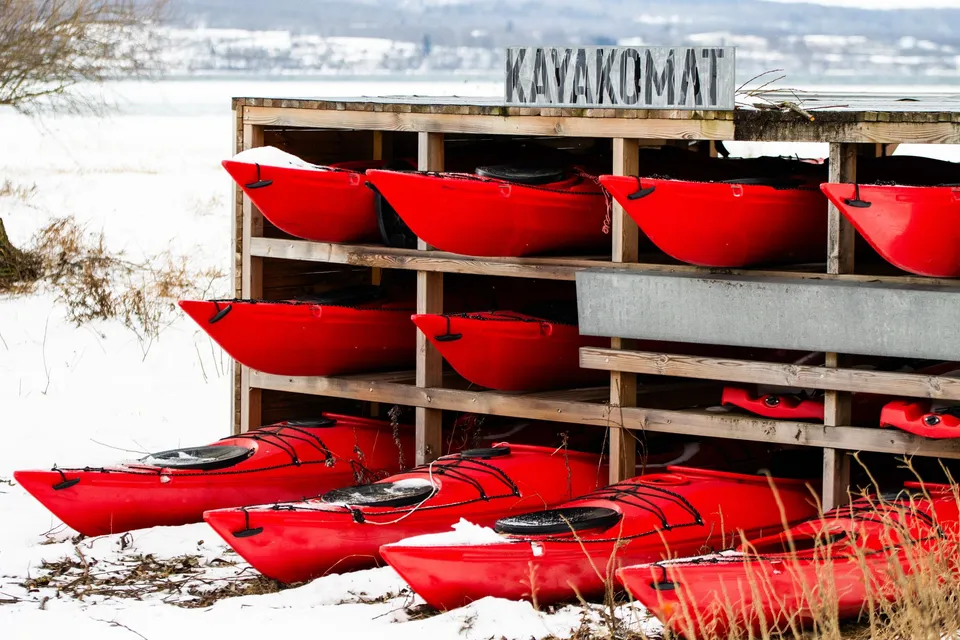 Red kayaks in winter storage by the lake