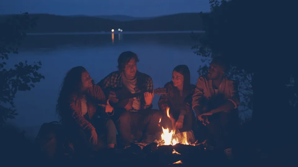 Friends around the campfire by the lake