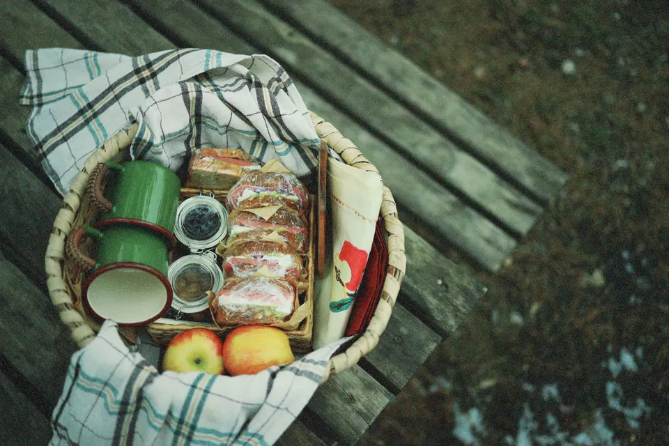 Picknickkorg med smörgåsar och äpplen