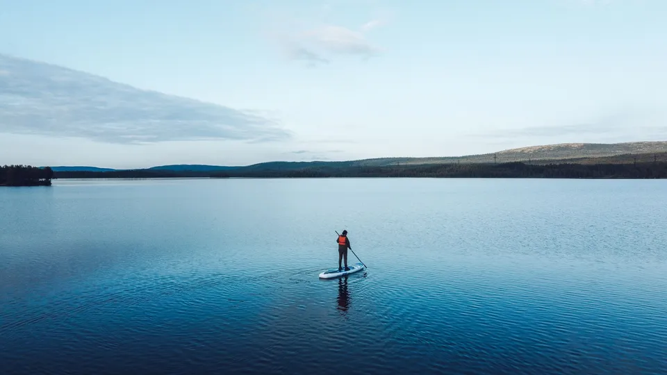 Lone paddle boarder on a calm lake
